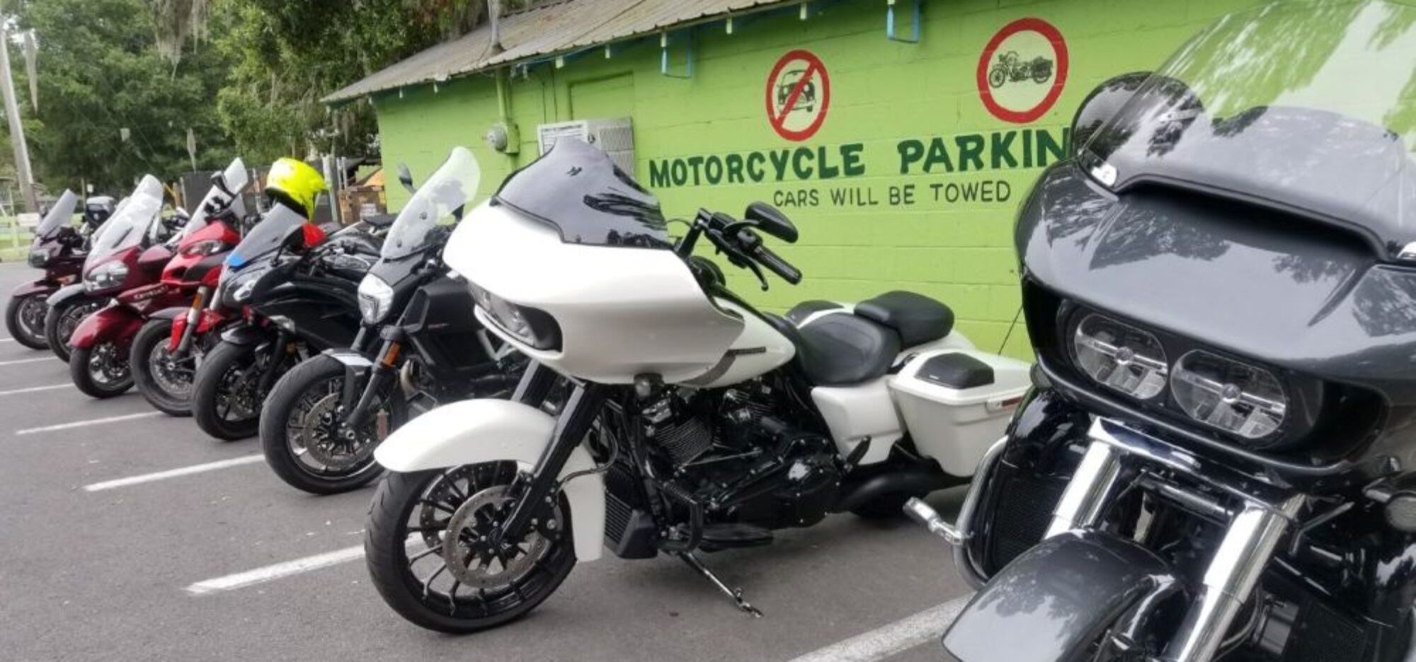 group of motorcycles against a green wall